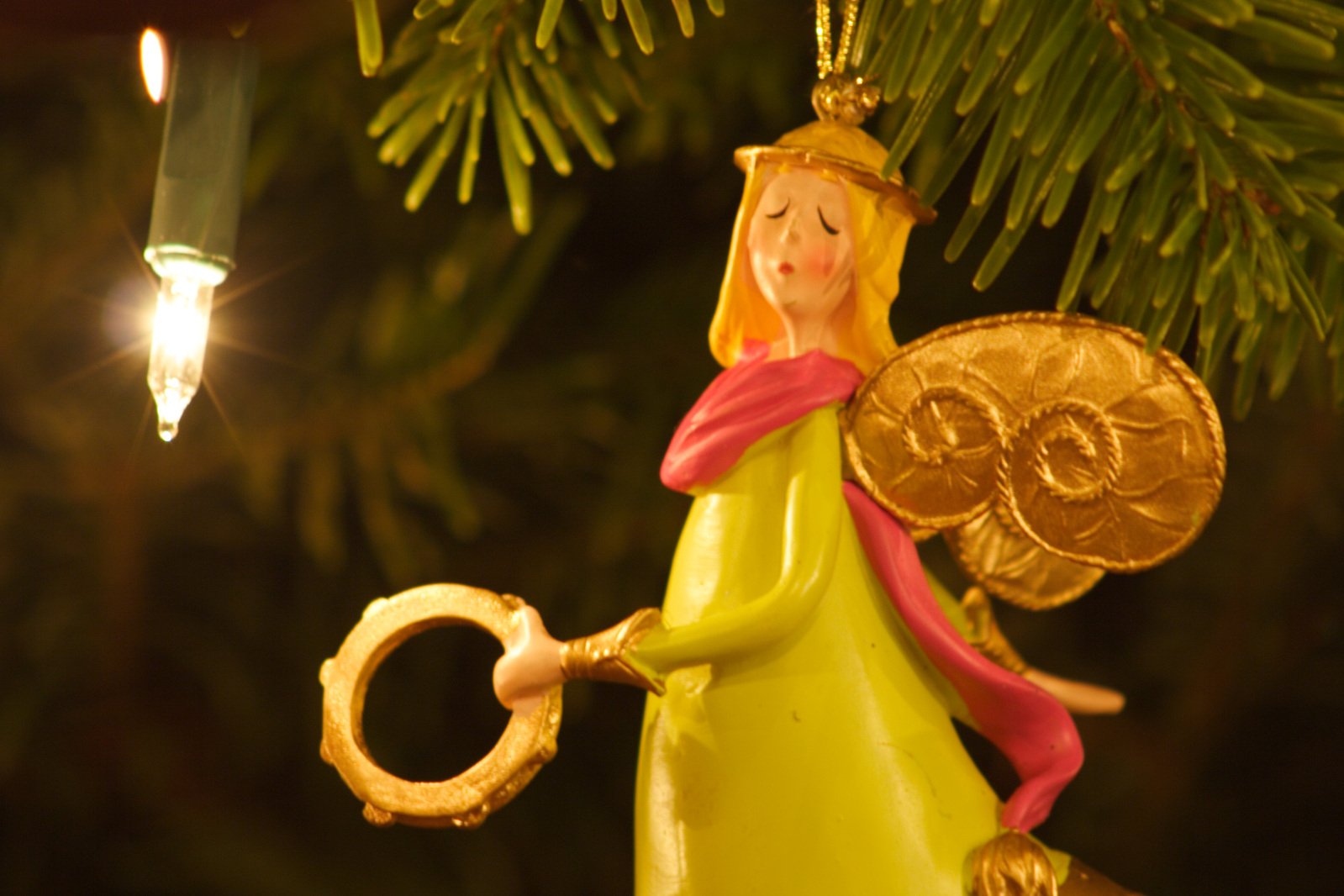 a christmas ornament with an angel and a golden circle