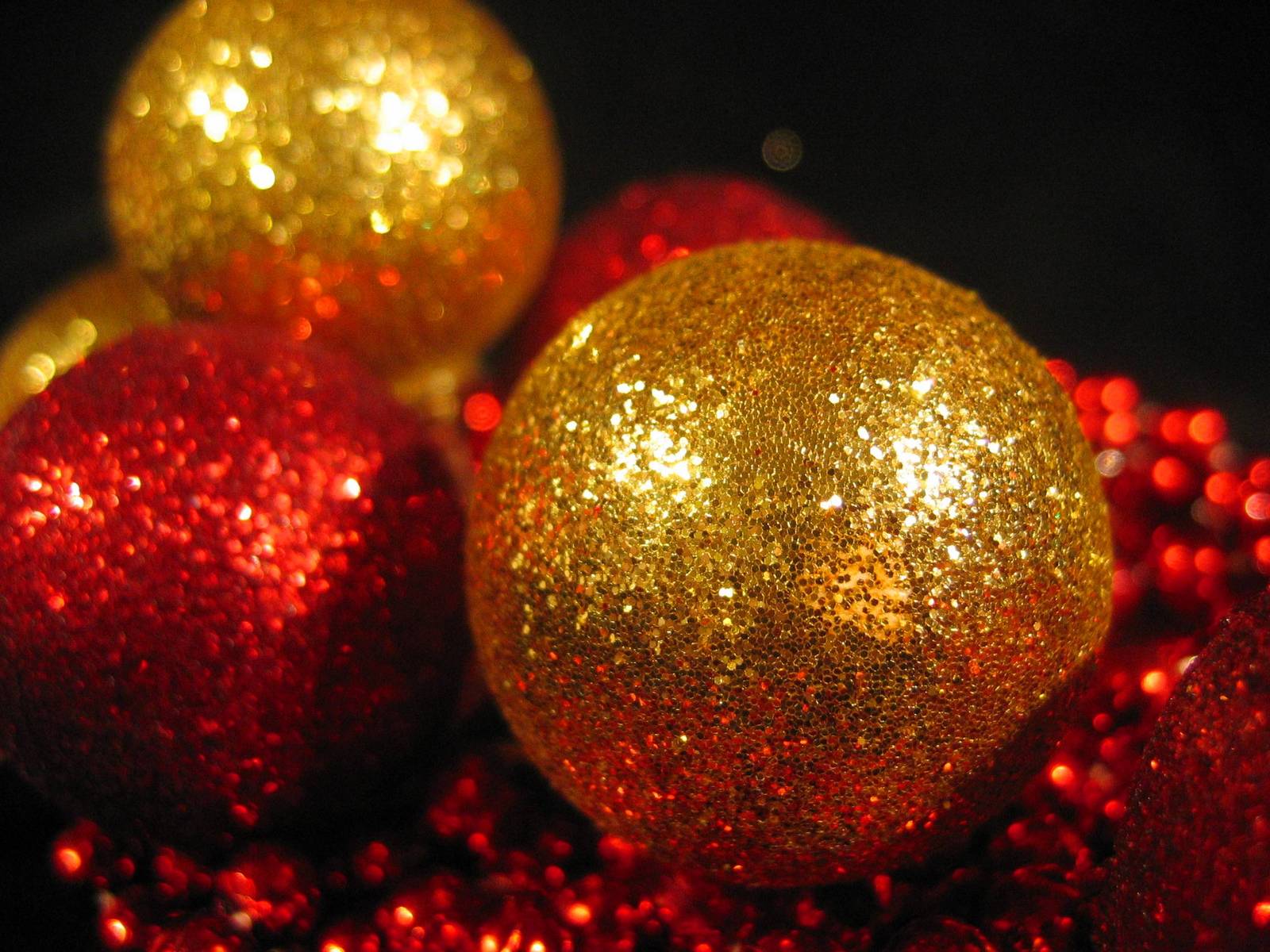 a close up view of red and gold glitter balls