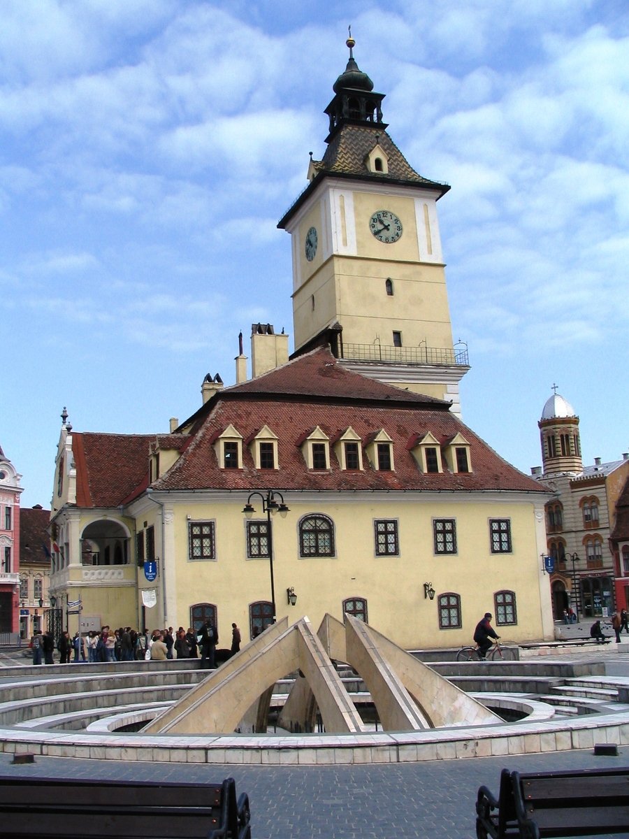 the building has a tower and two pointed clocks on it