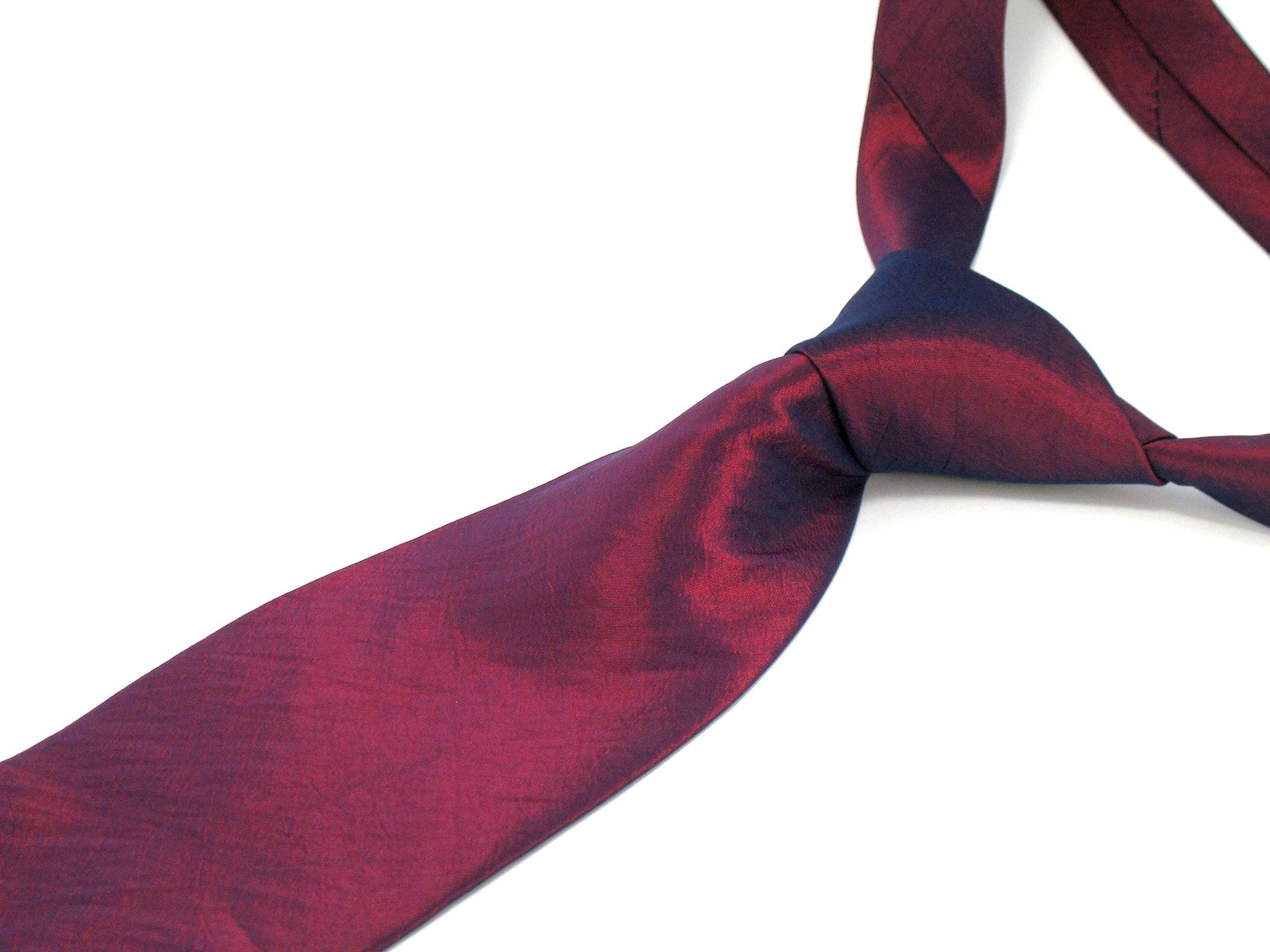 a burgundy colored tie is laying across a white surface