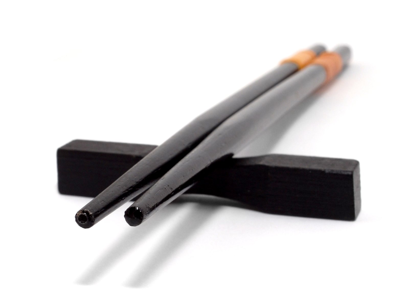 two black and brown sticks are in the middle of one on a white surface