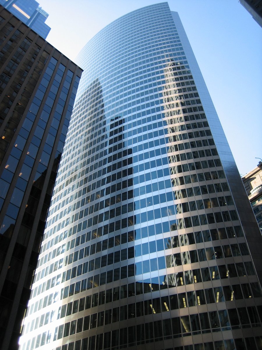 buildings are reflecting off the curved windows of the building