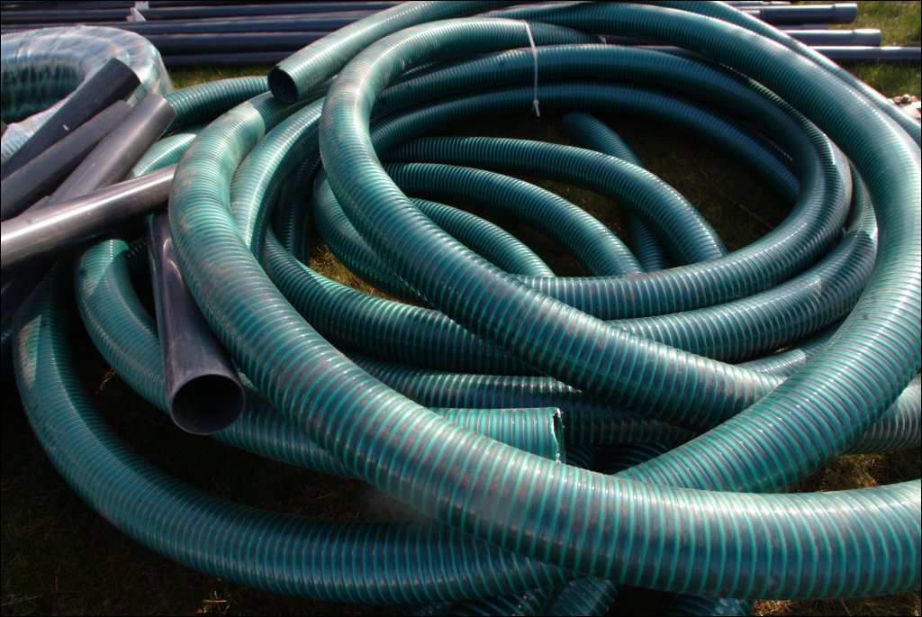 there is a large collection of different types of garden hoses and holders