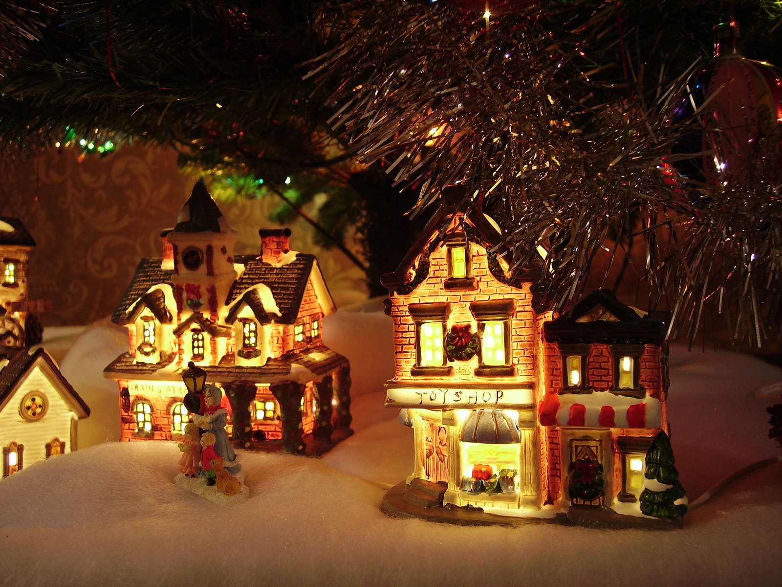 lighted christmas village and tree with many small houses