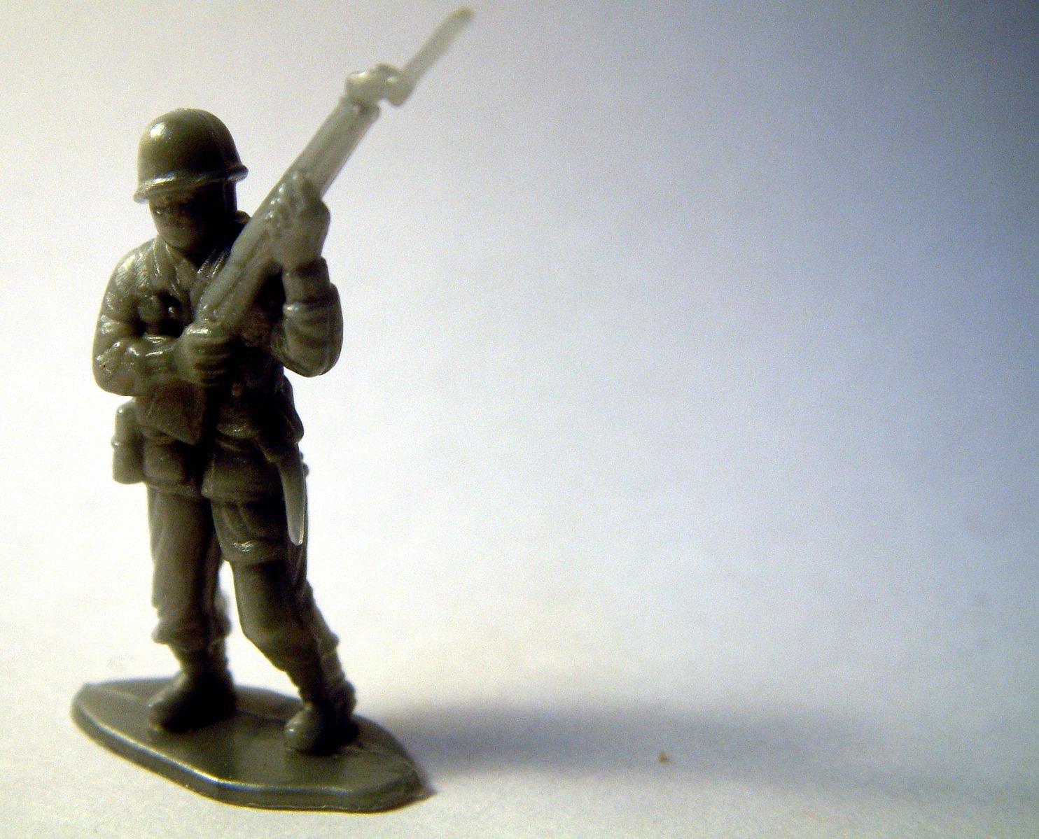 a toy soldier is holding a weapon on a base