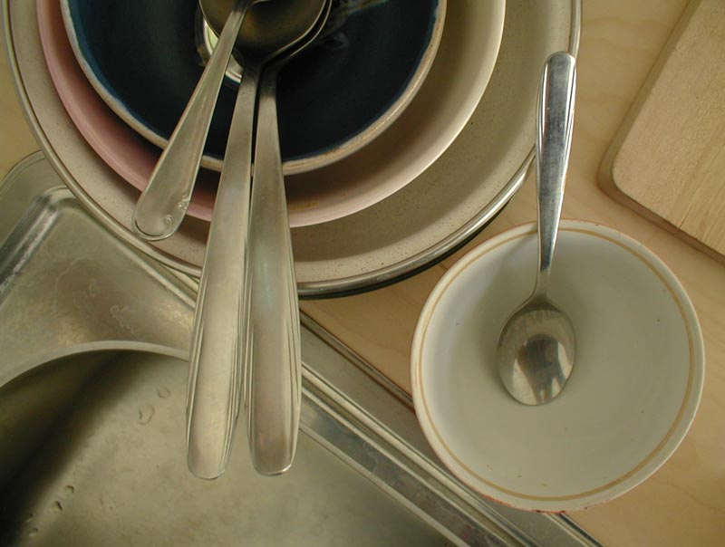 the fork is on top of dishes next to a spoon and bowl