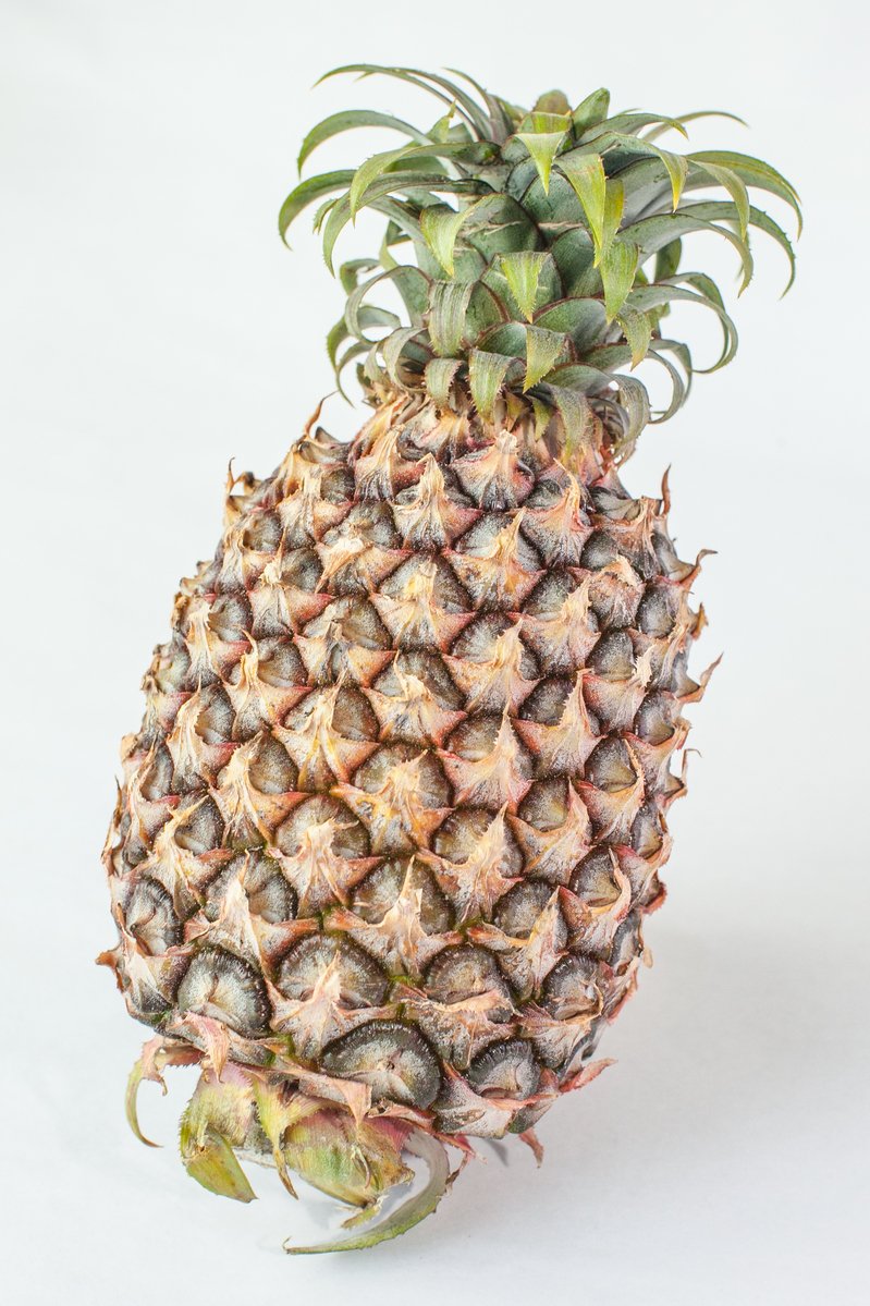 a pineapple fruit still sliced on a white background