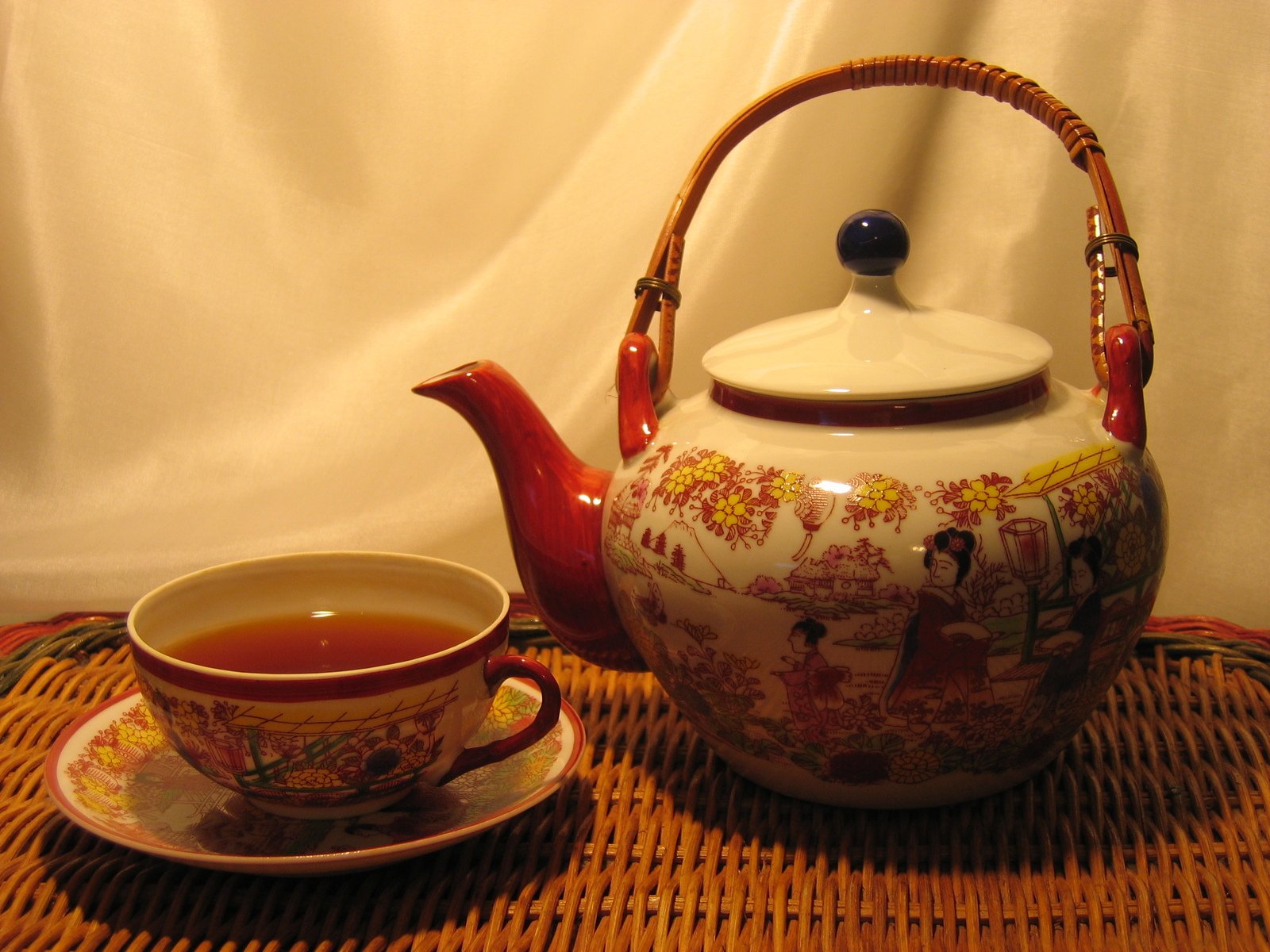 a teapot with a cup next to it and a small plate