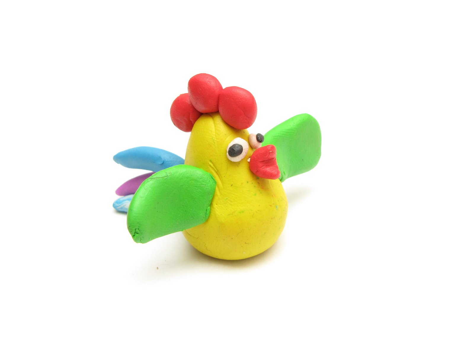 a rubber toy chicken is sitting on a white surface
