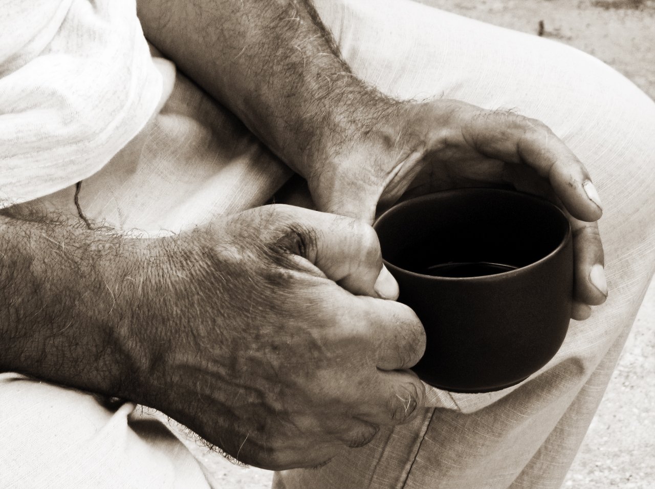 an old man holding a cup of coffee