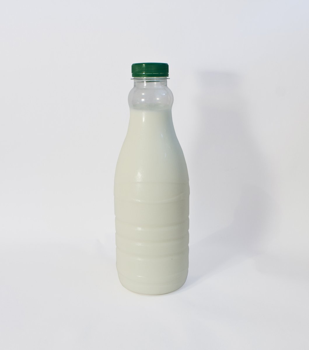 a bottle of white liquid with a green cap