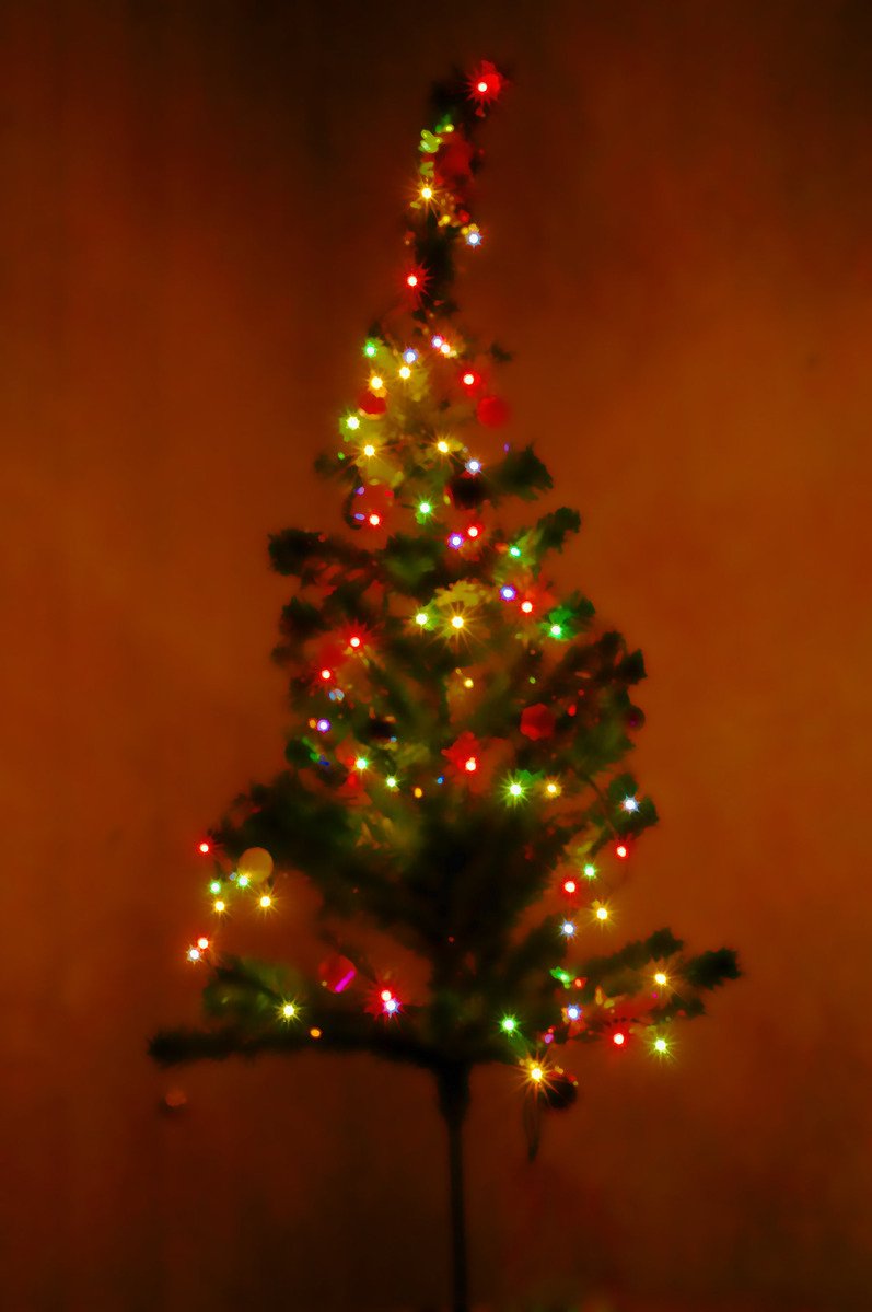 the small christmas tree is dressed up with colorful lights