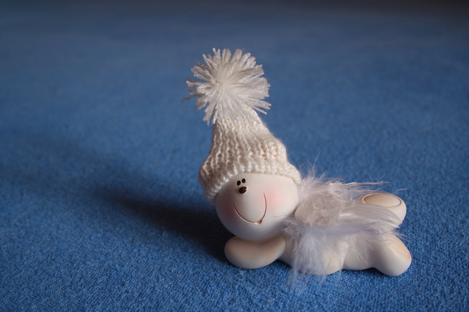 the stuffed animal has white fur and white hat