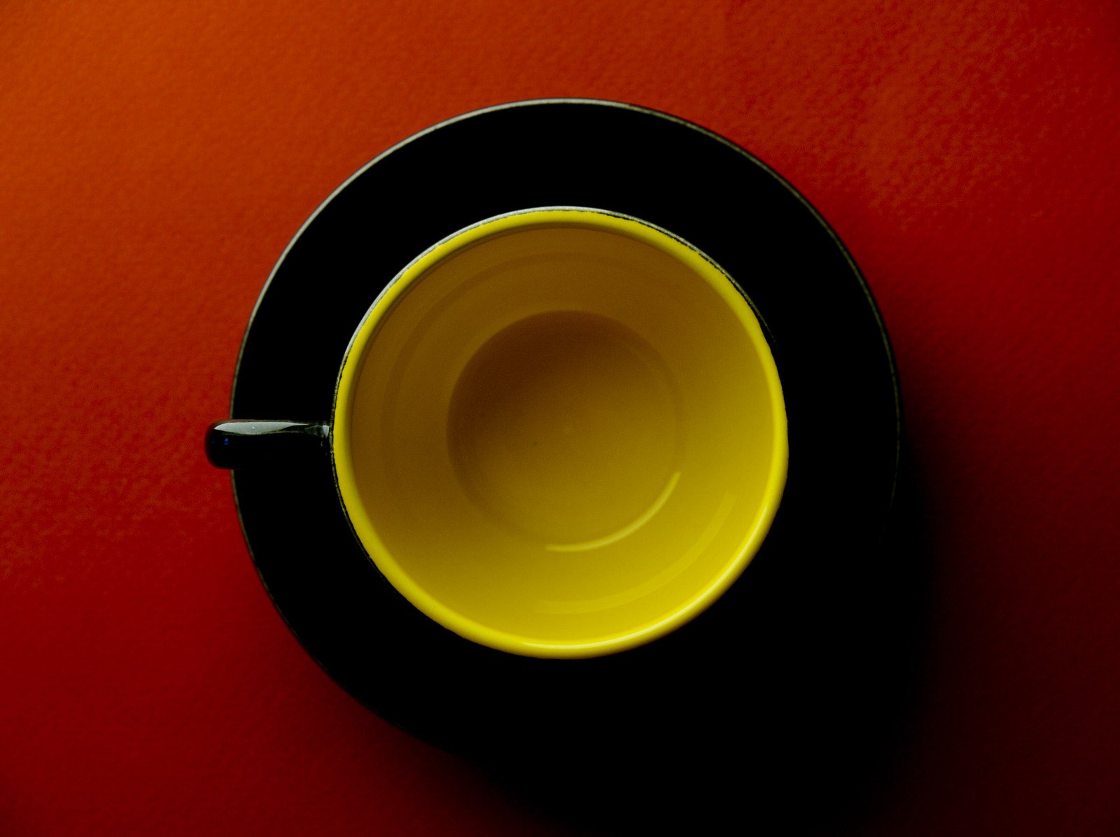 yellow and black bowl set against a red background