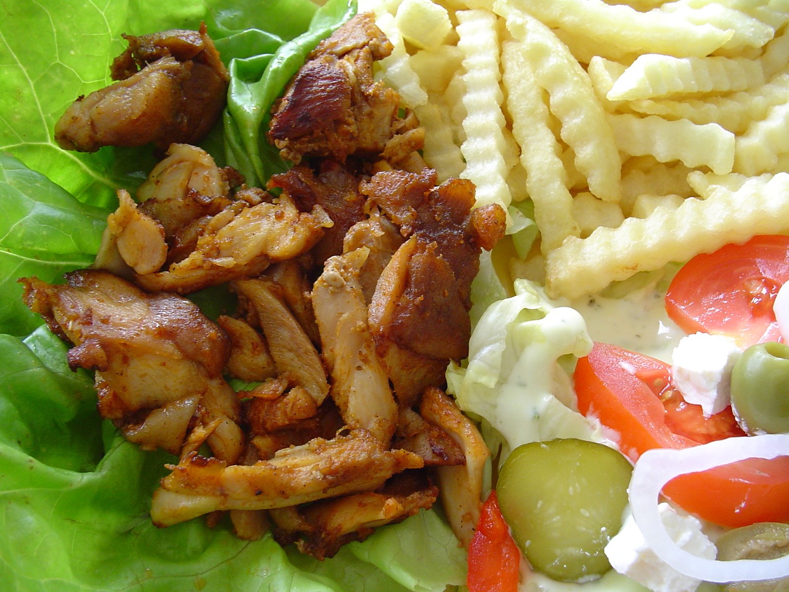 a close up of food on a plate with greens