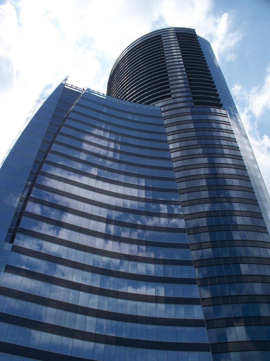 a large tall glass skyscr in the middle of a sunny day