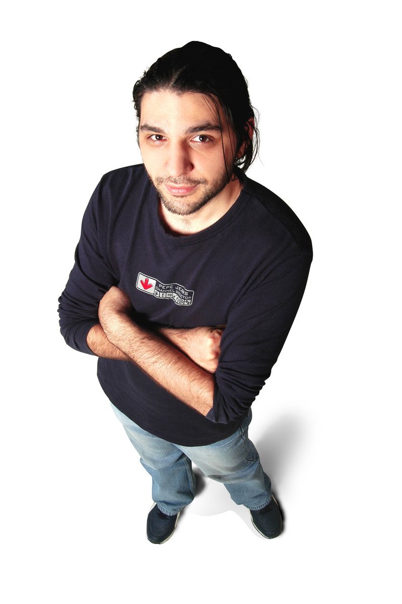 a man wearing a blue t - shirt and jeans is posing