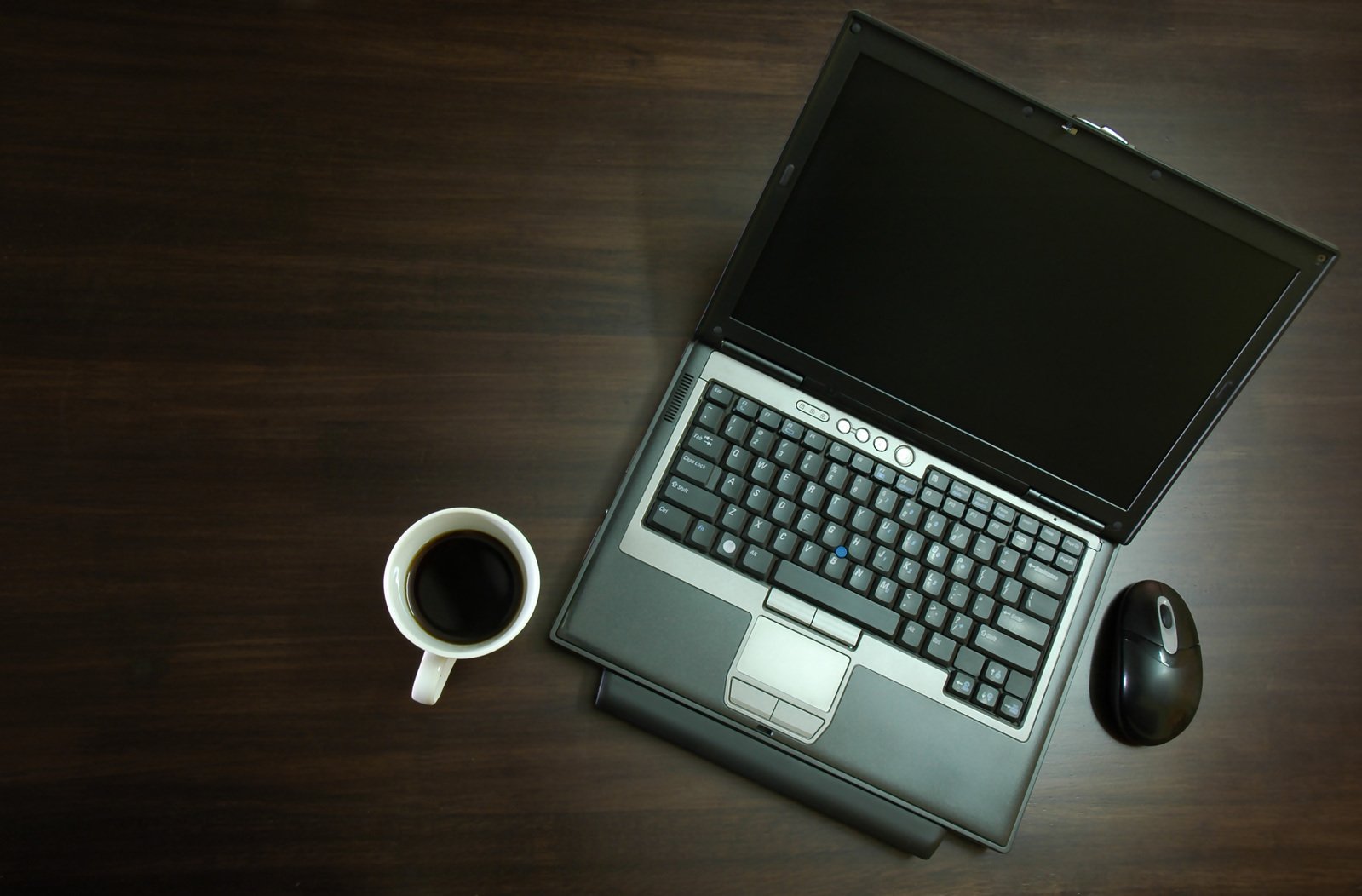 a laptop with a cup of coffee next to it