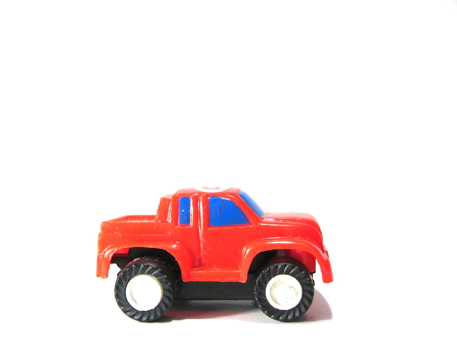 the toy truck is orange and blue on the white floor