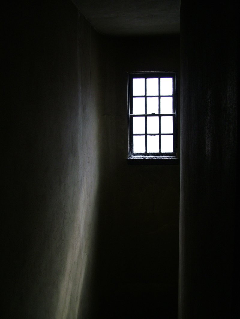 a dark hallway with an empty window at night