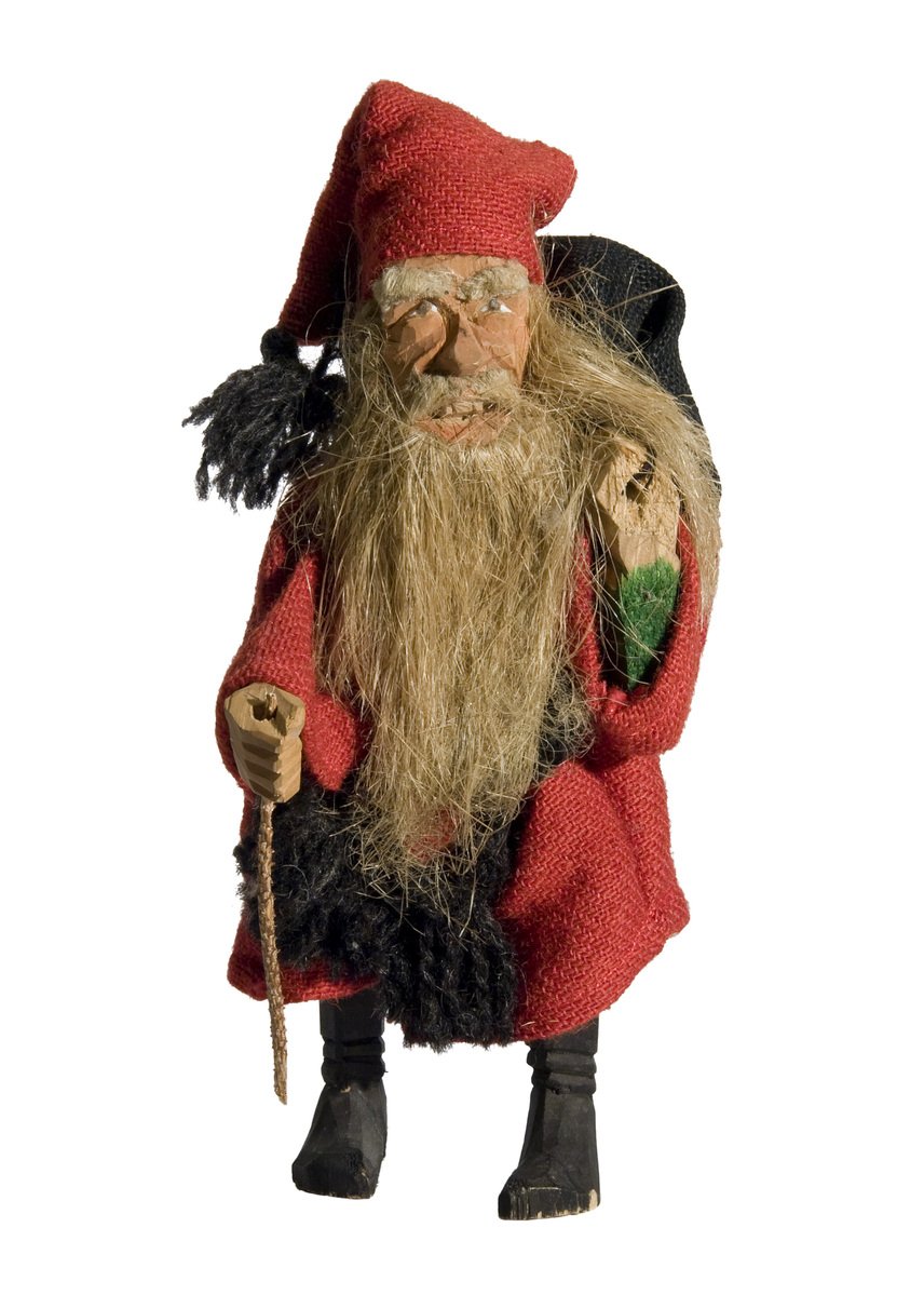 a red santa figurine holding a green plant