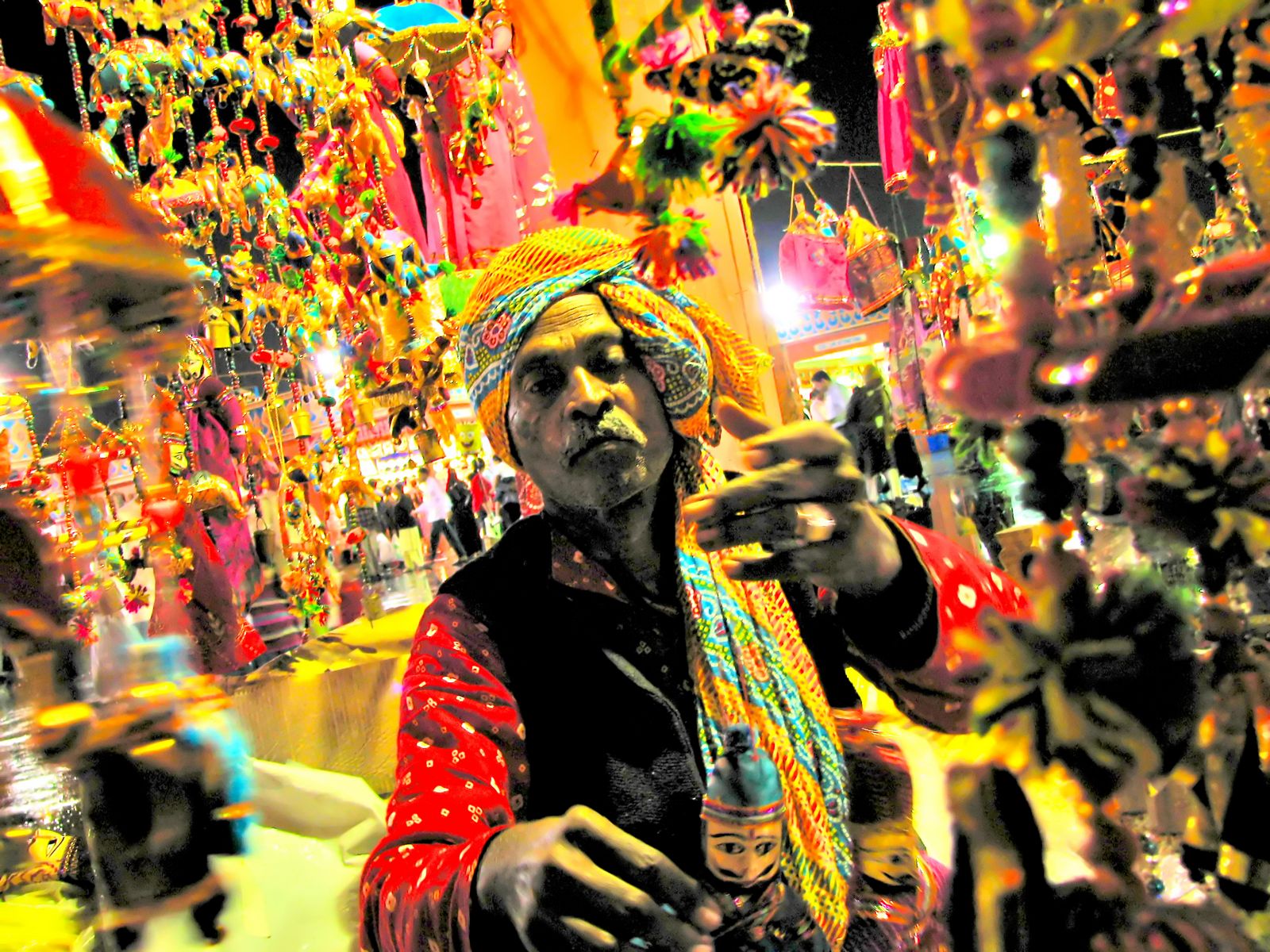 an image of a colorful indian man looking at his cell phone