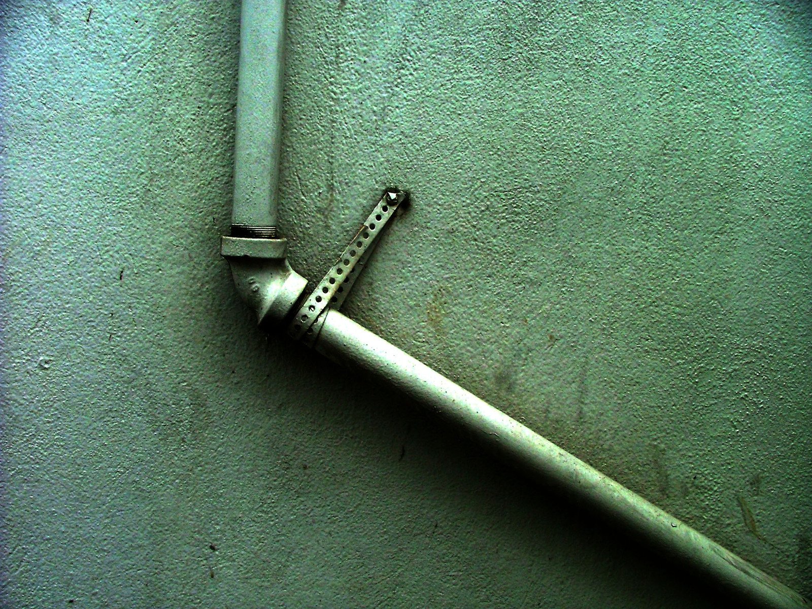 a white razor and a blue handle on a wall