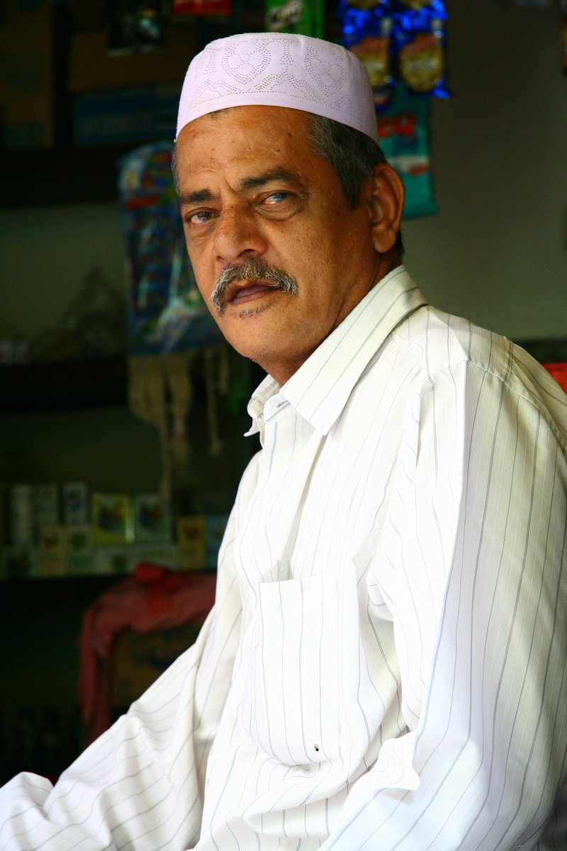 an older man in a colorful outfit with a mustache