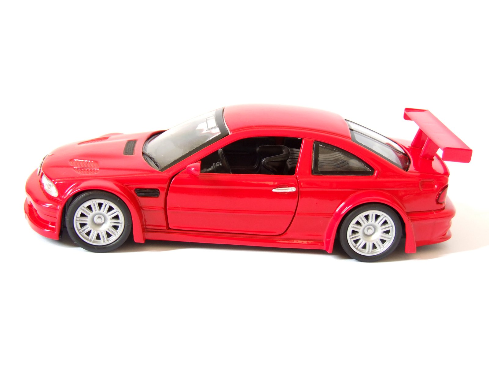 a red toy car is seen on a white background