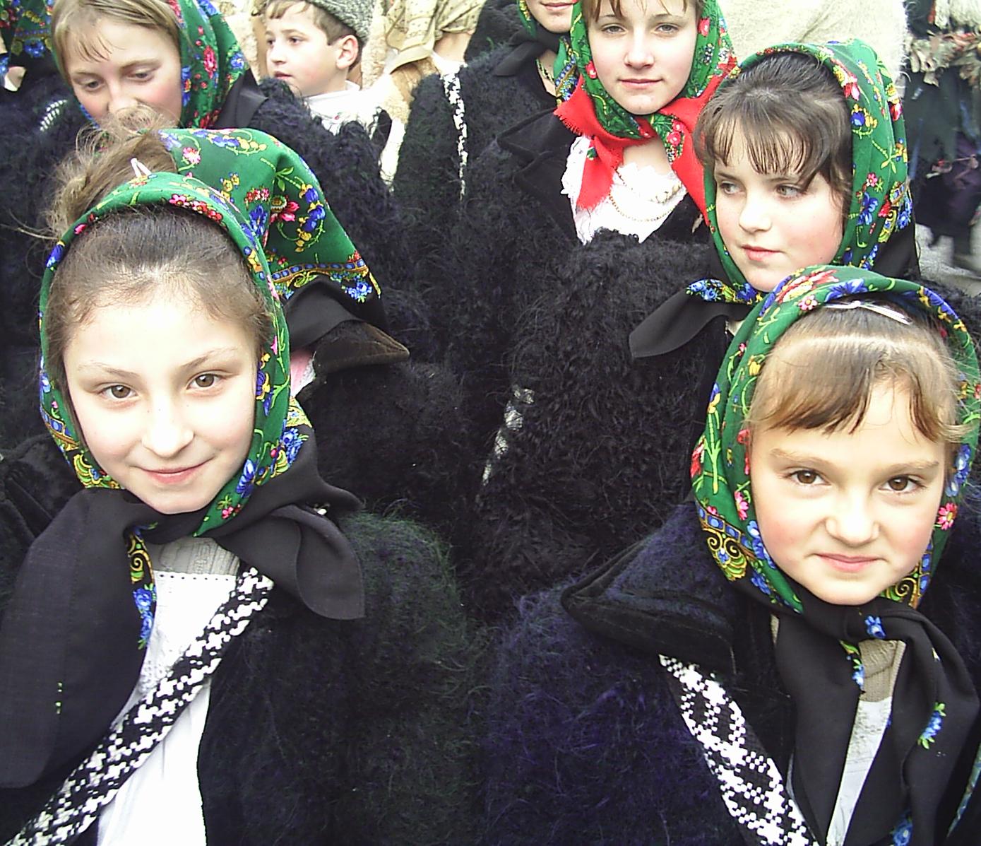 many young children wearing black coats with hoods