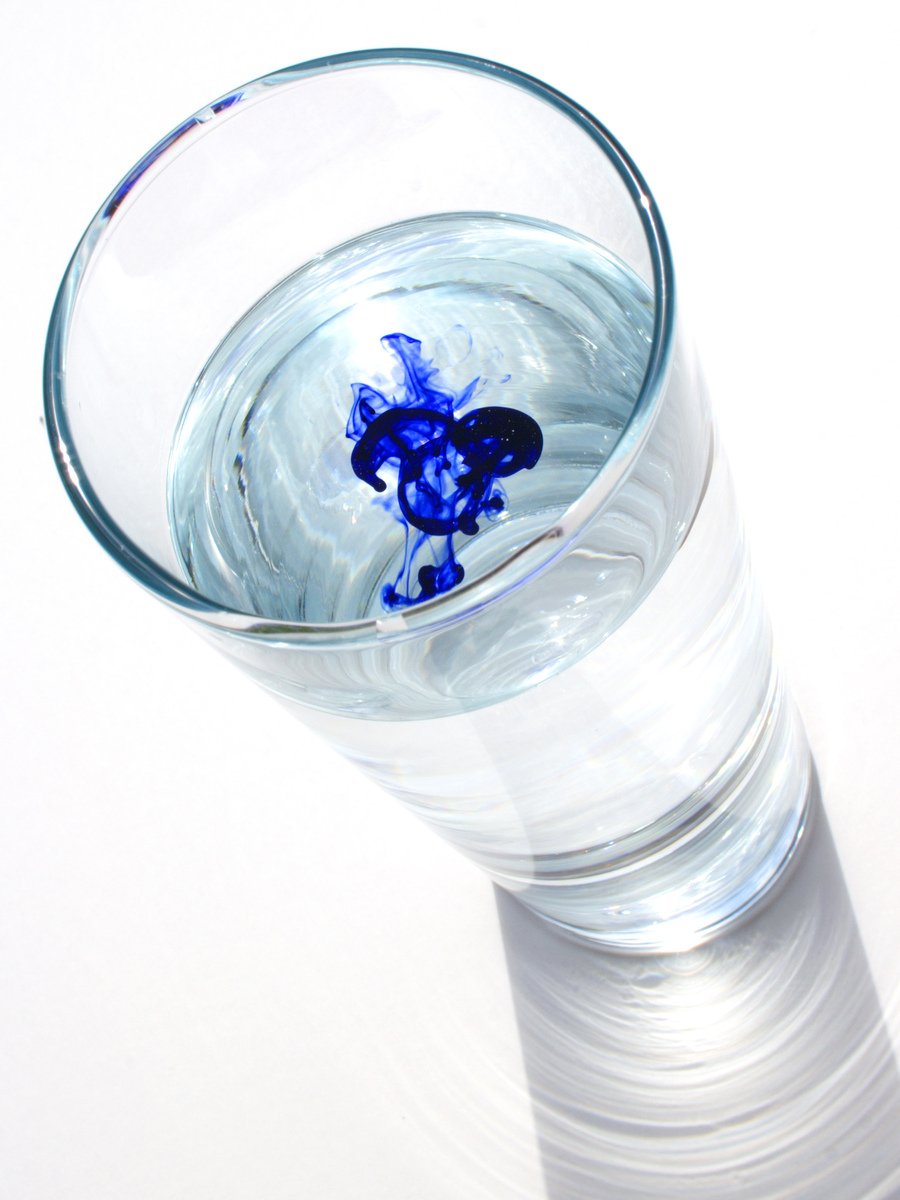 an abstract po of a clear glass with blue stuff floating in it