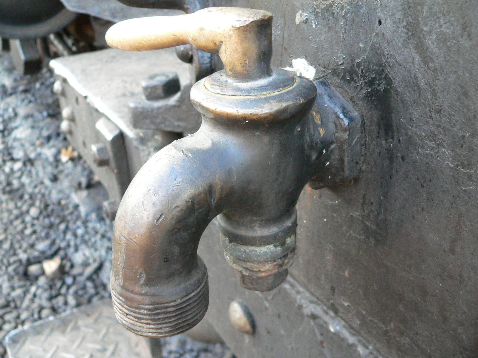 a close - up of an old faucet near a wall