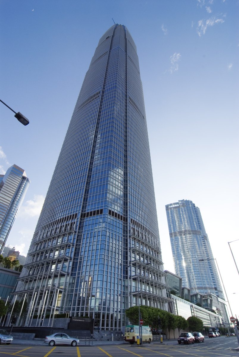 a very tall glassy skyscr next to some buildings