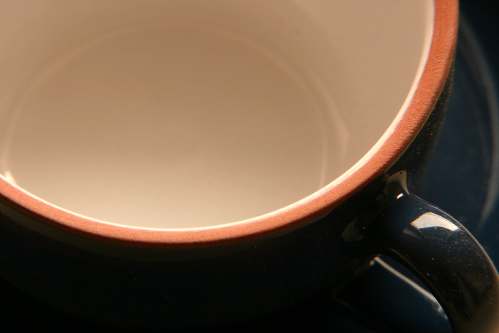 a black and orange coffee cup sitting on a blue tray