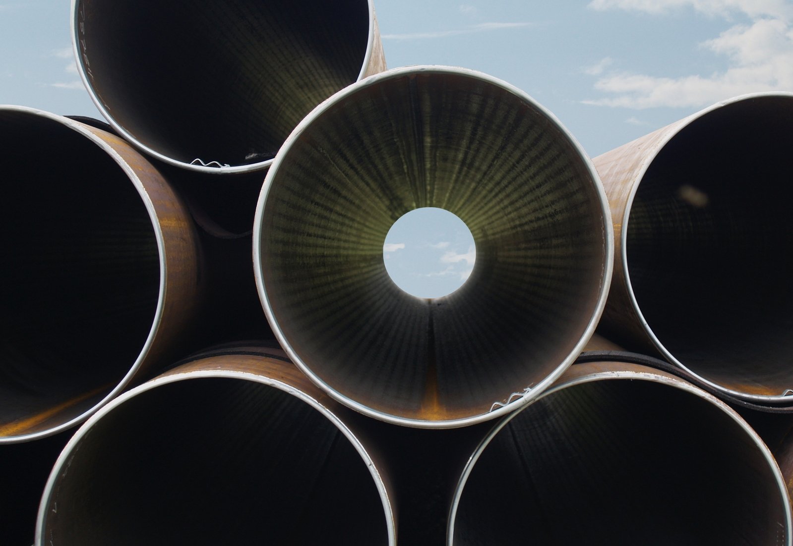 a large stack of steel pipe's at a factory