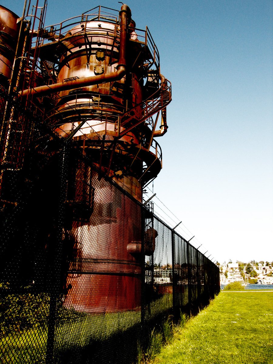 a red pipe sitting on the side of a green field