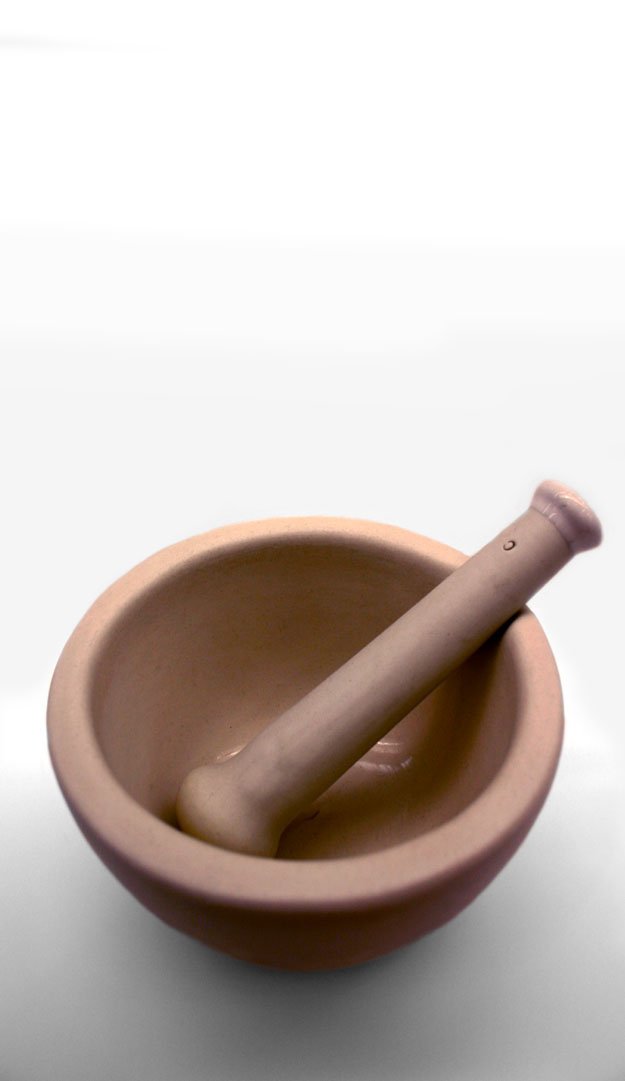 an empty bowl and a wooden spoon on the white surface