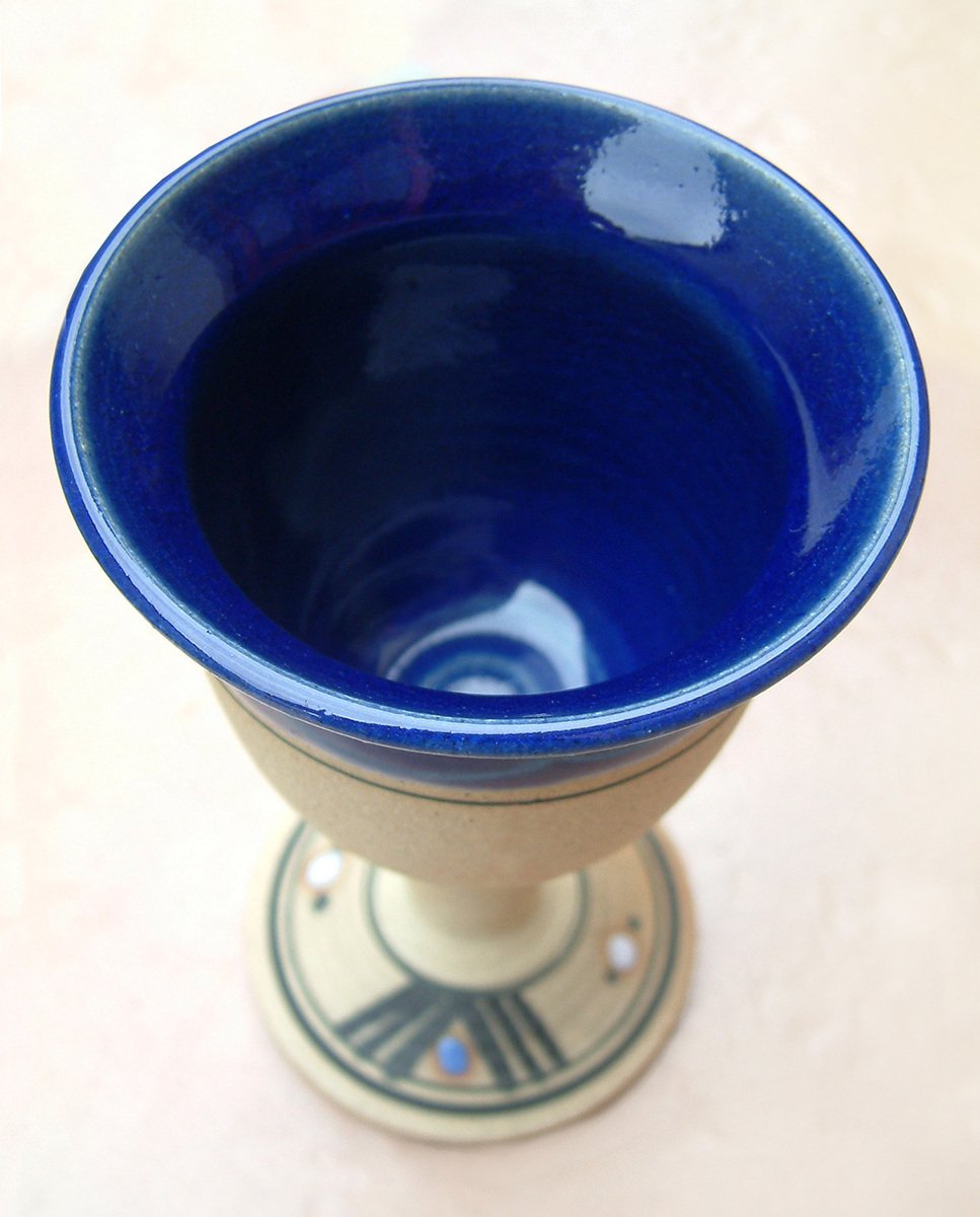 a blue bowl on top of an old pottery stand