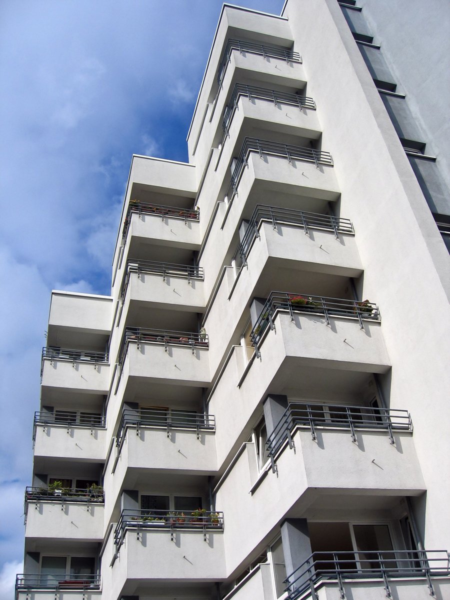 a tall white building with balconies and many windows