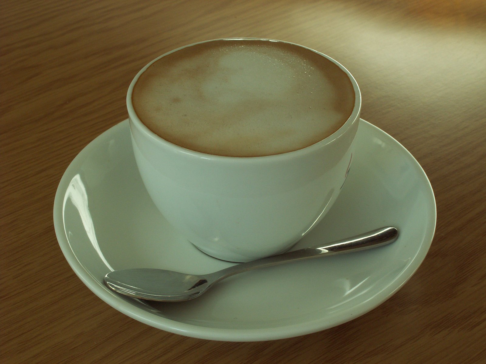 a coffee cup on top of a saucer and a spoon