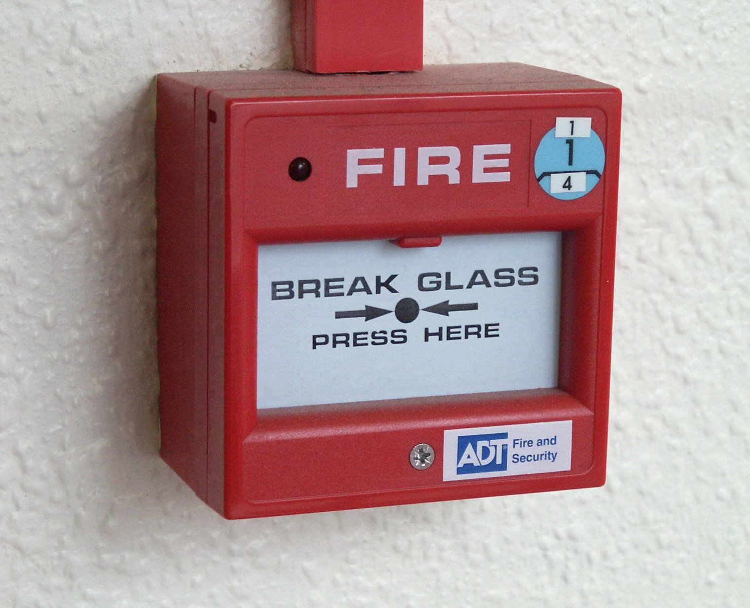 a fire alarm that is hanging on a wall