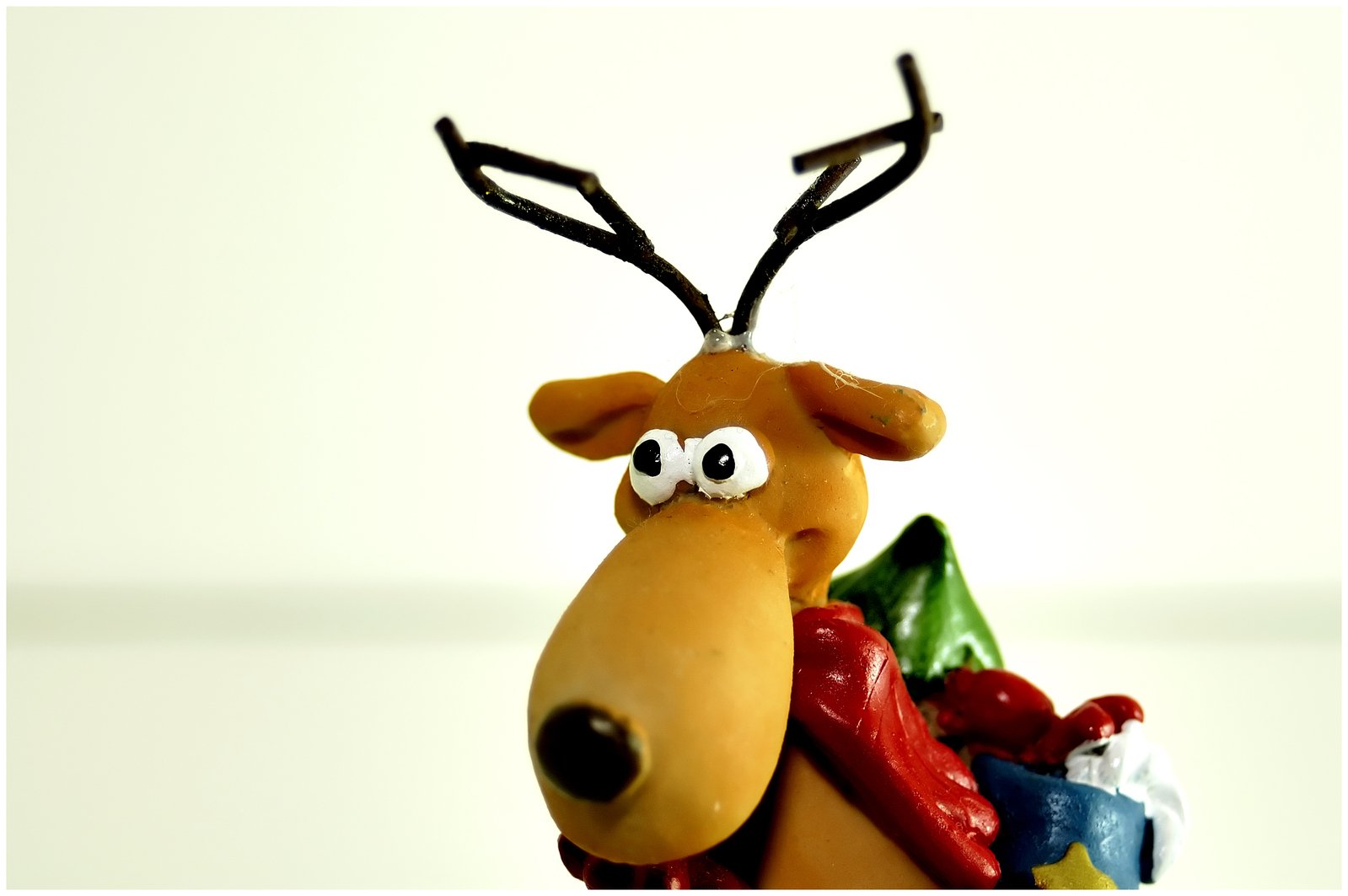 a reindeer with christmas decorations and googly eyes