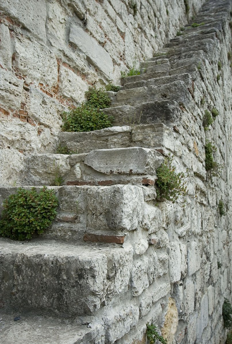 some stone stairs that are by a brick wall