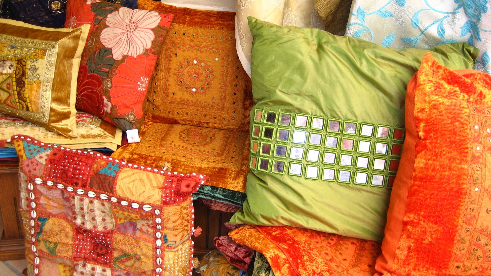 several colorful pillows piled next to each other on the floor
