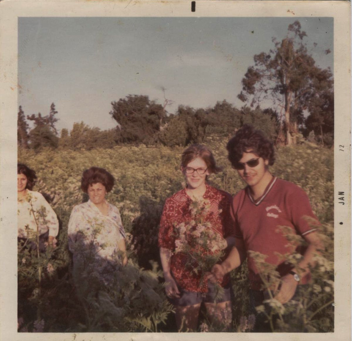 a group of people standing in front of a grassy field