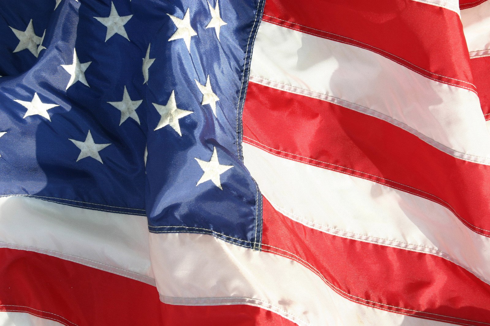 several large american flags with white stars on them