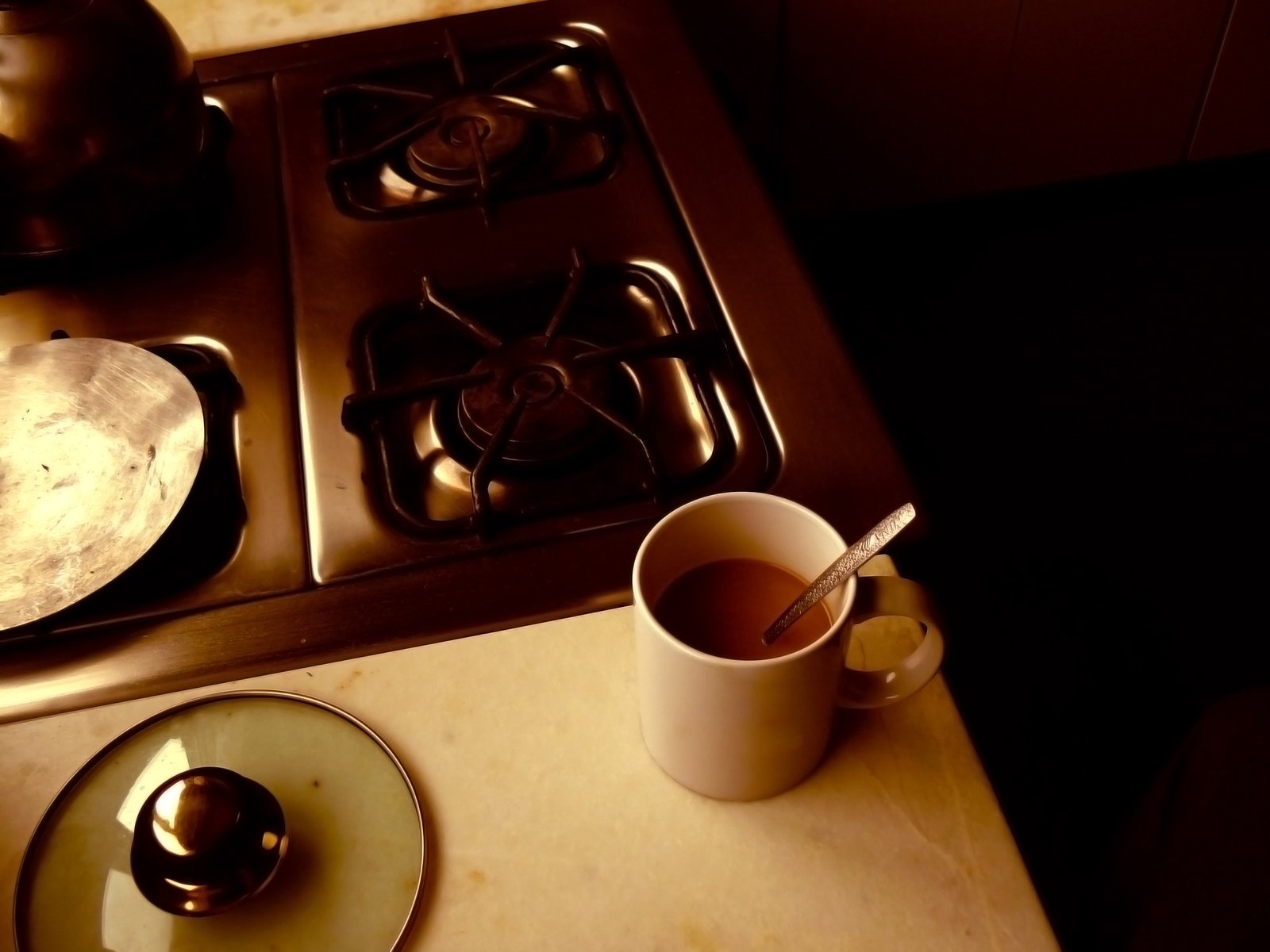 a cup of coffee and tea set on top of a stove