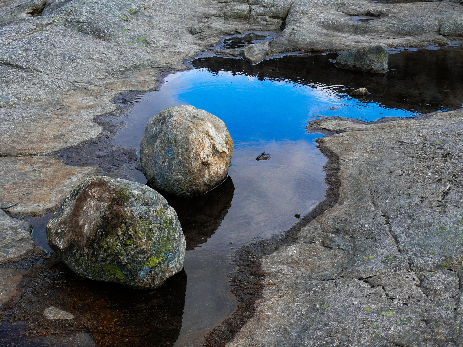 rock formations with water in the middle and sky reflected