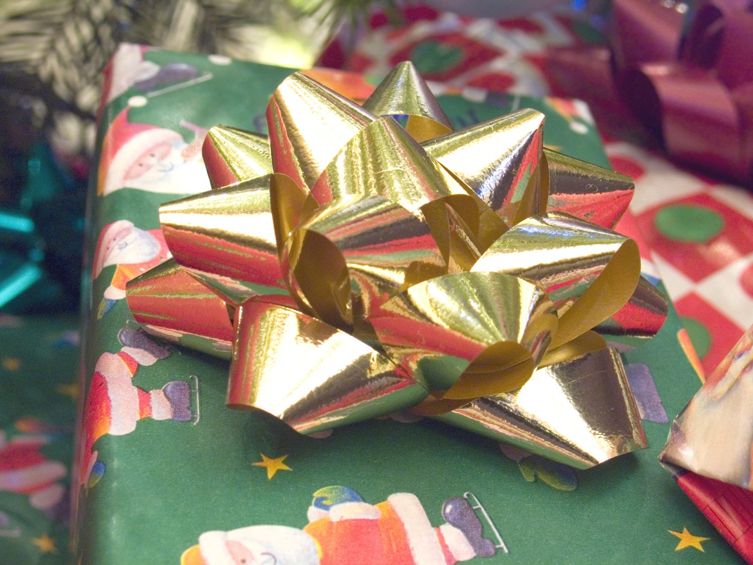 a christmas present wrapped in gold foil, with a bow on it