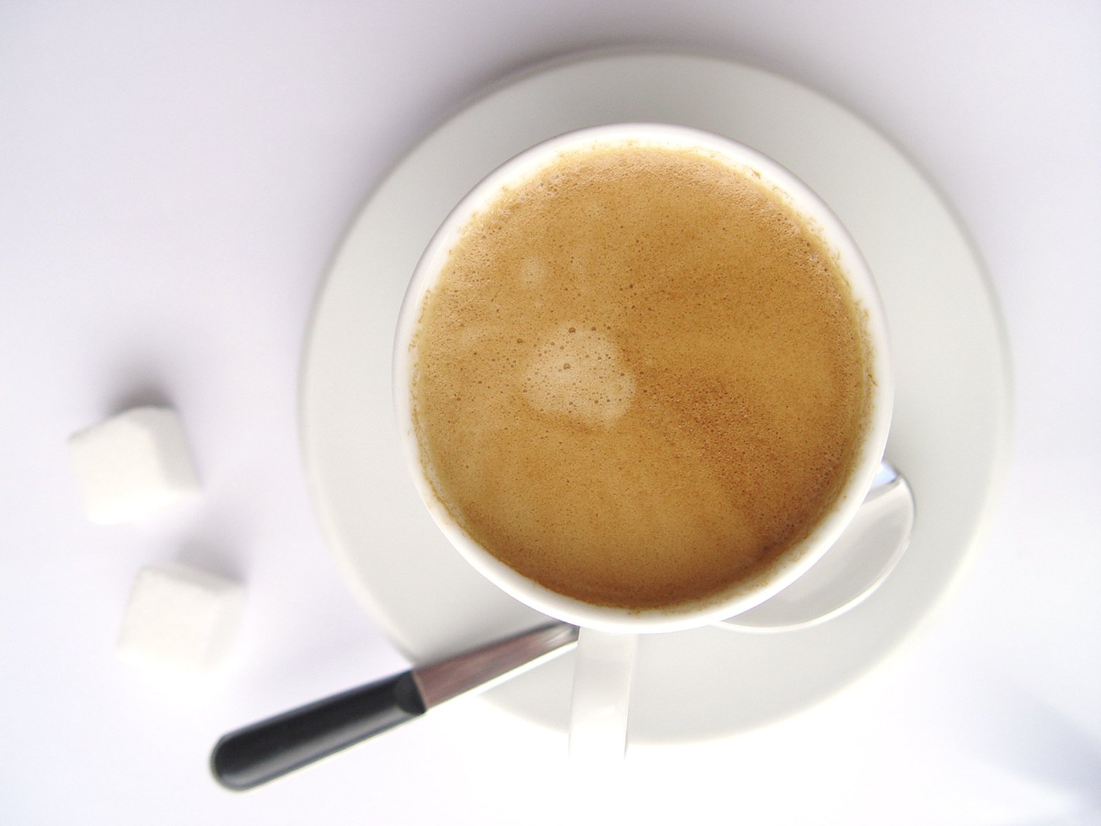 a cup of coffee is sitting on the white saucer